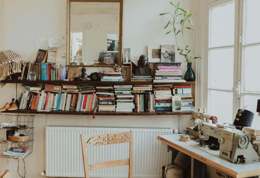 Warm and inviting home office featuring a sewing machine, bookshelves, and vintage decor. Perfect for creative inspiration.