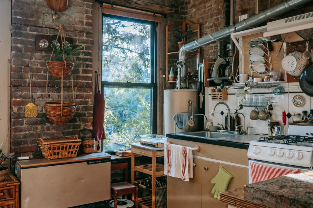 Charming rustic kitchen featuring wooden decor, exposed brick, and appliances with a sunlit window view.